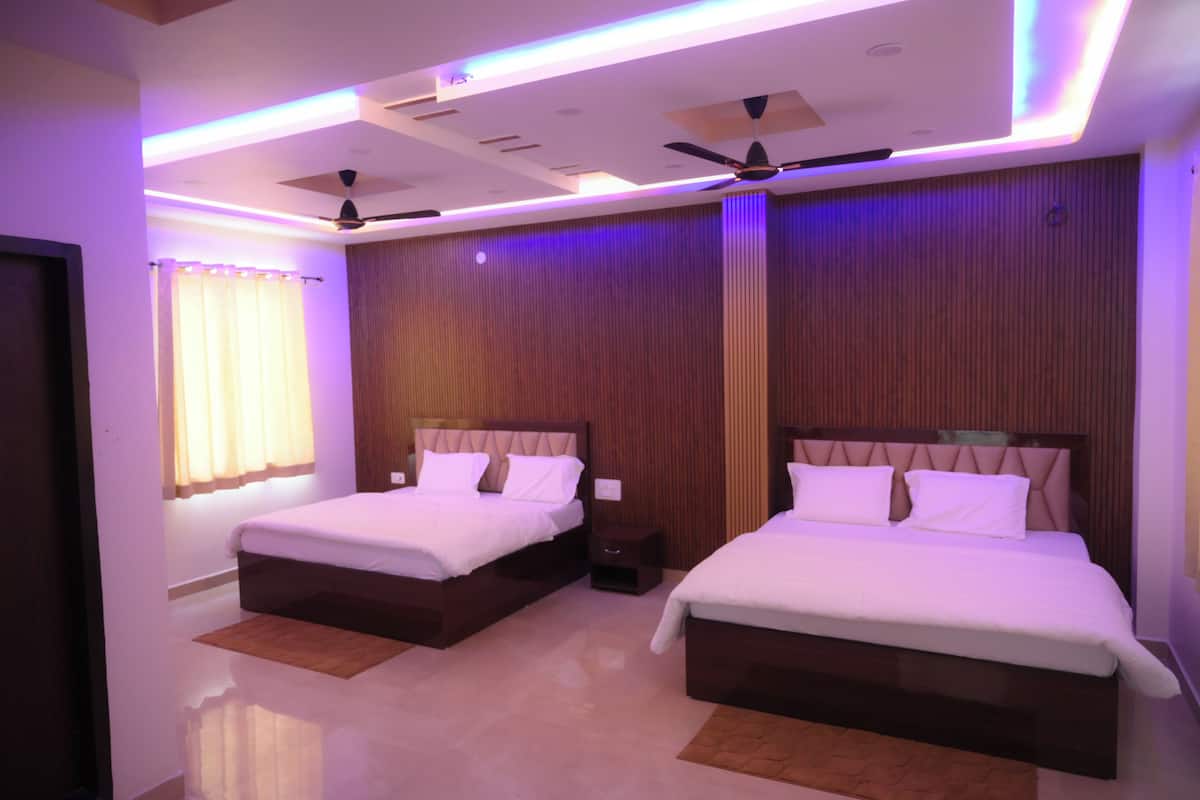 A hotel room with two beds, ceiling fans, and a wooden panel wall.