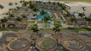 Un resort con piscina central, varias opciones de restauración y una amplia zona de estar al aire libre.