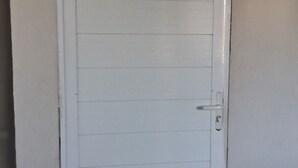 A white door with horizontal paneling, a handle, and a lock. - Pousada Serra Azul (Juquiá)
