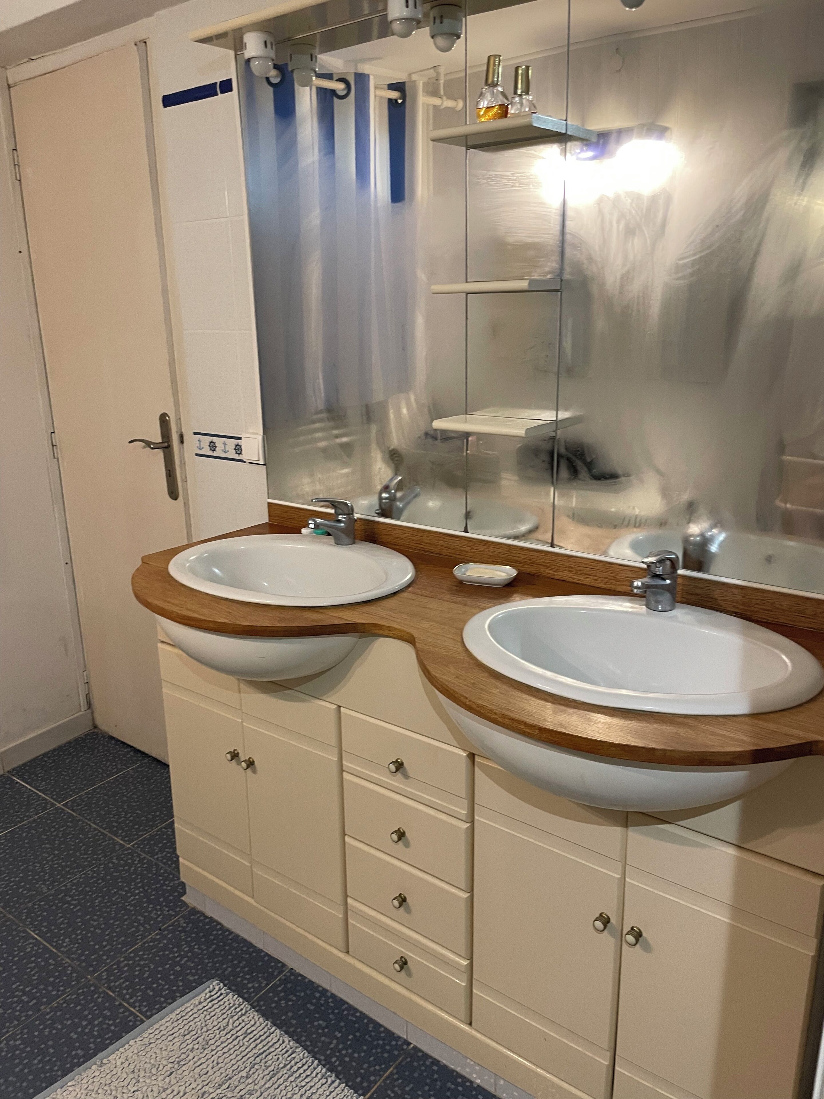 A bathroom with two sinks, a mirror, and a shower curtain.