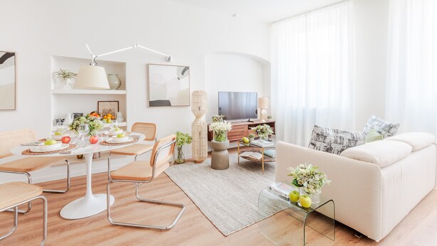 Una sala de estar moderna con comedor, un sofá y un televisor.