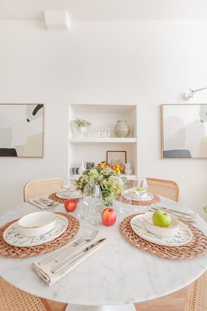 A round dining table with placemats, plates, cutlery, and a vase with flowers. - Letizia Plaza in Lucca (Lucca)