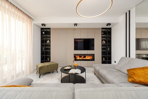 Ein modernes Wohnzimmer mit Kamin, Sofa, Couchtisch und Bücherregal.