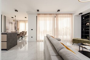 Ein modernes Wohnzimmer mit einer Couch, einem Essbereich und einer Küche.