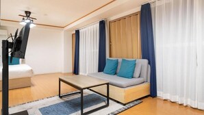 A modern living room with a sofa, a coffee table, and a television. - Urban Plaza (Osaka)