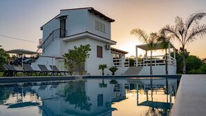A modern two-story building with a swimming pool in front.