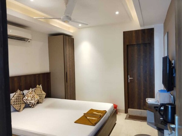 A hotel room with a bed, wardrobe, TV, and a small kitchenette. - Eennra Kaansabbati (Paschim Medinipur Sadar)