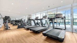 Et fitnesscenter med løbebånd, crosstrainere og styrkemaskiner.