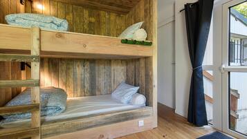 Ein Etagenbett mit Holz Kopfteil und einem Fenster mit Vorhang.