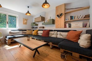 A cozy living room with a sectional sofa, wooden coffee table, and built-in bookshelves.