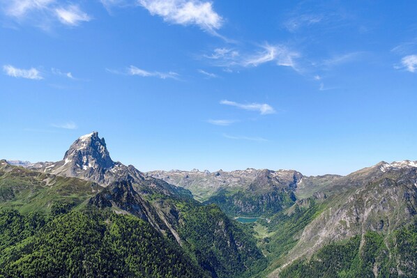 A mountain landscape with a prominent peak and surrounding forested areas.