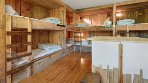 Un intérieur en bois avec des lits superposés et un comptoir blanc.