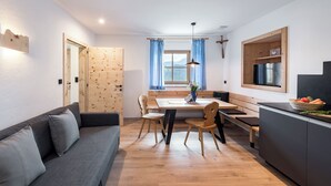 Een moderne keuken met houten kastjes, een eettafel en een inbouwoven.