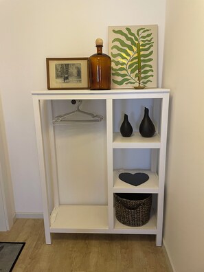 A white shelving unit with a framed picture, a brown bottle, and a decorative plant. - Haus zu den Bergen – Modern Vacation Rental in the Kneipp Spa Town of Bad Tabarz (Bad Tabarz)