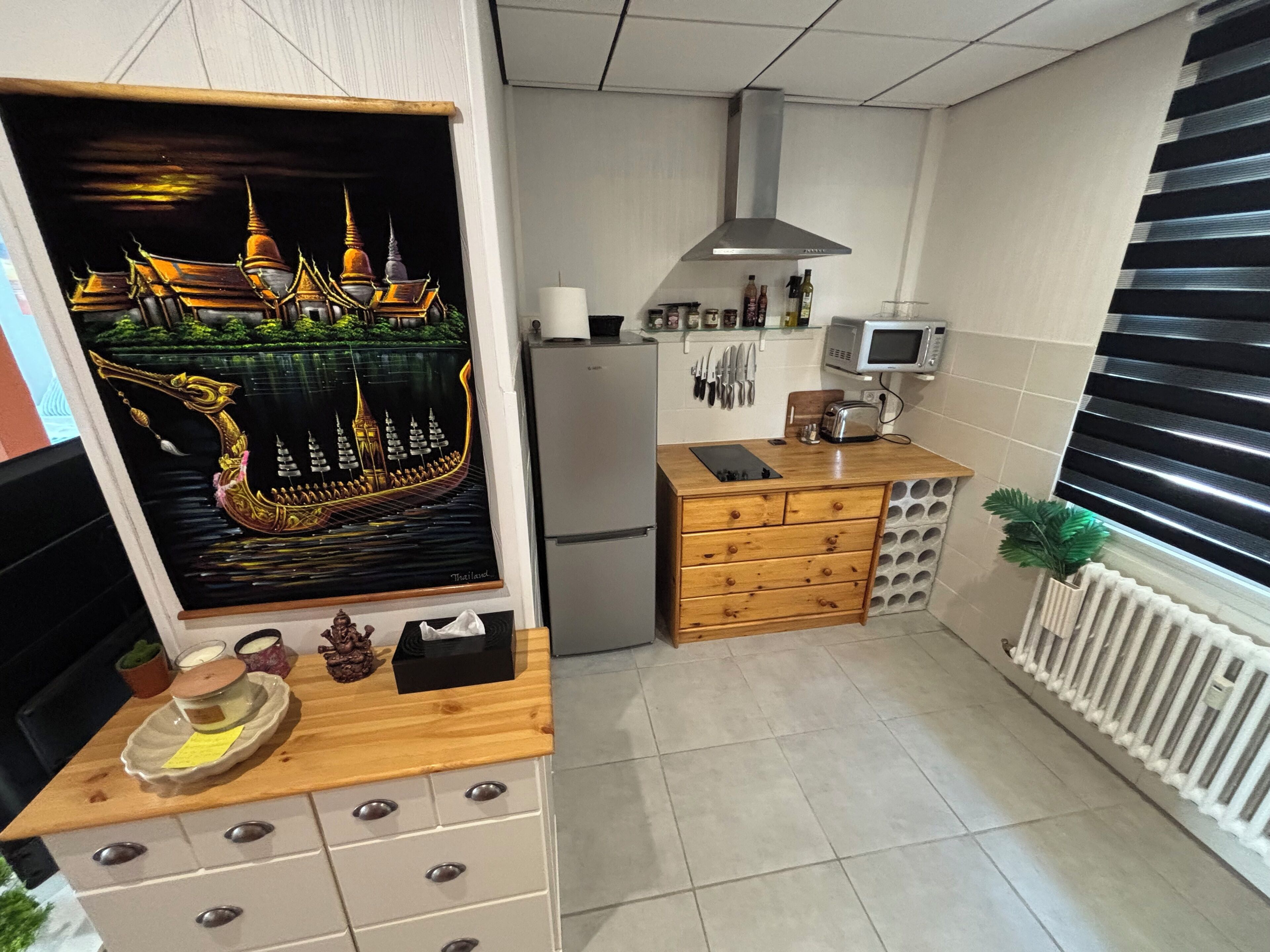 Una cucina con piano di lavoro in legno, un forno a microonde e un frigorifero.