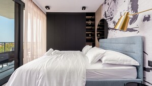 Een moderne slaapkamer met een groot bed, een hoofdeinde, een nachtkastje en uitzicht op de omgeving.