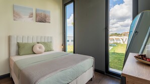 A bedroom with a bed, a window, and a view of the outdoors. - Lotus Villas & Suites (Polygyros)