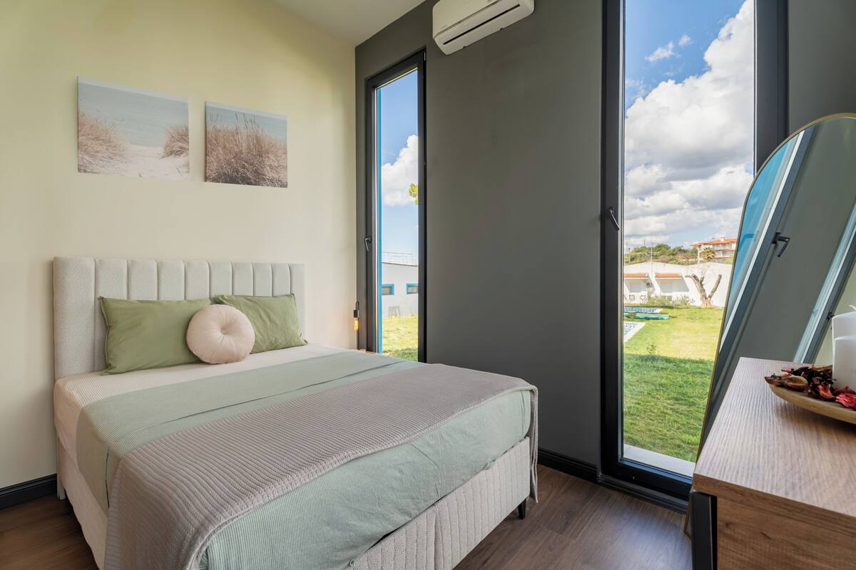 Une chambre à coucher avec un lit, une fenêtre et une vue sur l’extérieur.