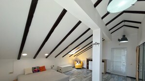 Ein Schlafzimmer mit Bett, Sessel, Nachttisch und Kleiderschrank.