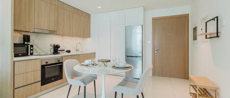 Eine moderne Küche mit Essbereich, Holdekor, Backofen und Kühlschrank.