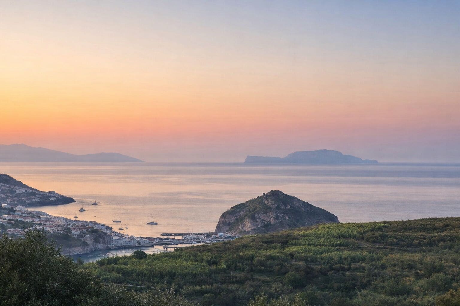 Un paisaje costero con un pueblo, barcos y colinas.