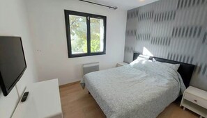 A bedroom with a bed, a TV, a window, and a radiator. - Vacation home in Apt (Apt)
