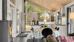 Una cucina moderna con un'ampia finestra, un'area pranzo con tavolo e sedie, e un camino.
