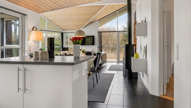 Una cucina moderna con isola centrale, zona pranzo con vista e un'ampia finestra.