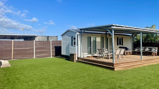 A mobile home with a covered patio, a fenced yard, and a lawn. - El Palmar Paradise . (El palmar, Vejer de la frontera)