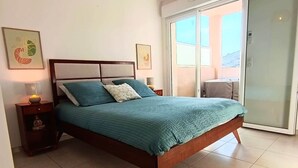 A bedroom with a bed, nightstand, lamp, and artwork on the wall. - L'Écrin d'Olmo: Charming & spacious terrace in a peaceful setting (Pietrosella)