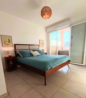 A bedroom with a bed, nightstand, lamp, and artwork on the wall. - L'Écrin d'Olmo: Charming & spacious terrace in a peaceful setting (Pietrosella)