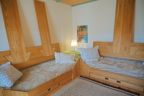 A room with two wooden beds, a nightstand with a lamp, and a framed picture on the wall. - Holiday Home 'Kohlstatt Hof Ferienhaus' with Mountain View, Private Terrace & Wi-Fi (Verano)