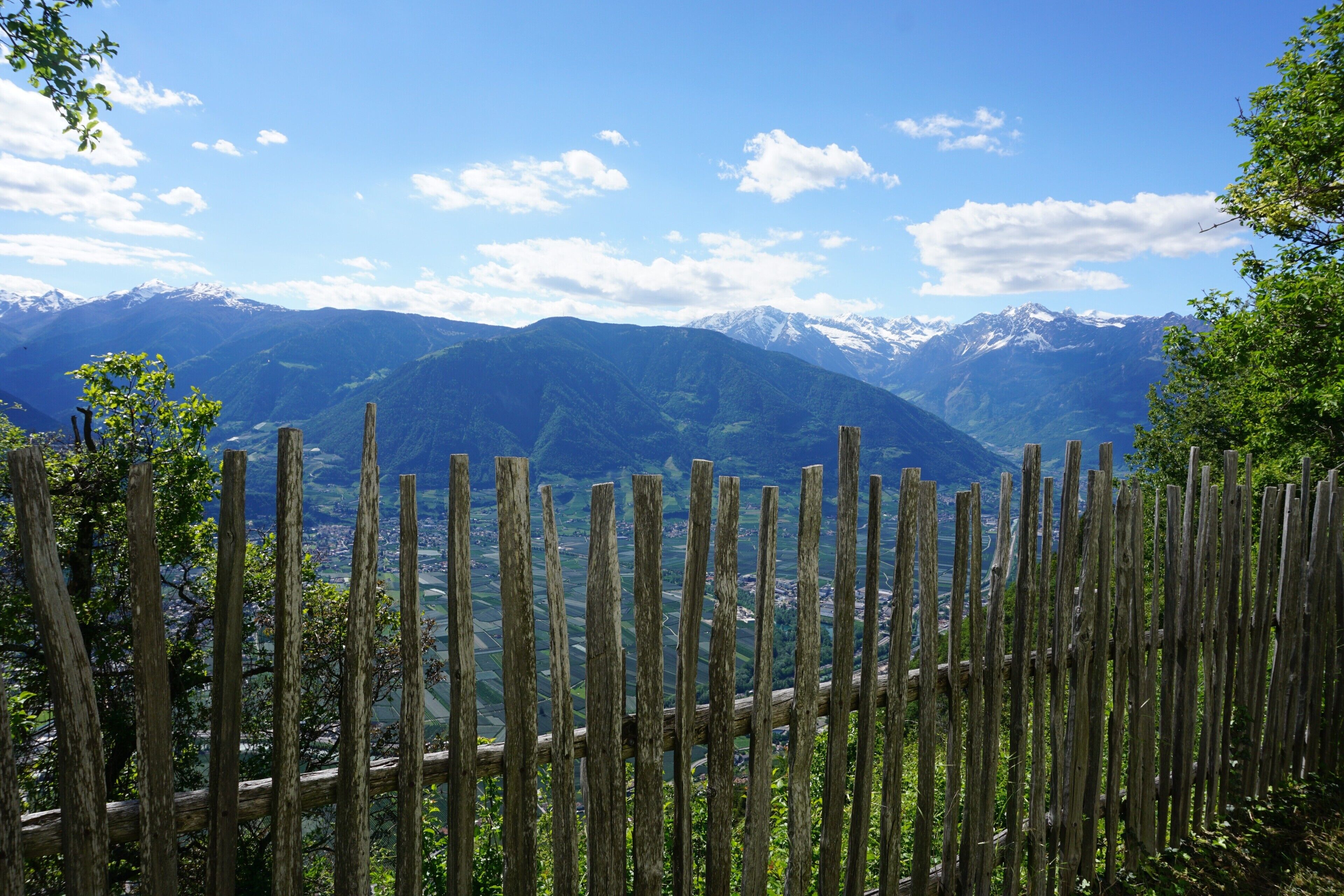 Una valla de madera con un paisaje montañoso al fondo.