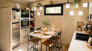 A modern kitchen with a dining table set for four, a built-in oven, and a window above the sink. - House - 2 private suites - cosy - 2'Monaco and port (Beausoleil)