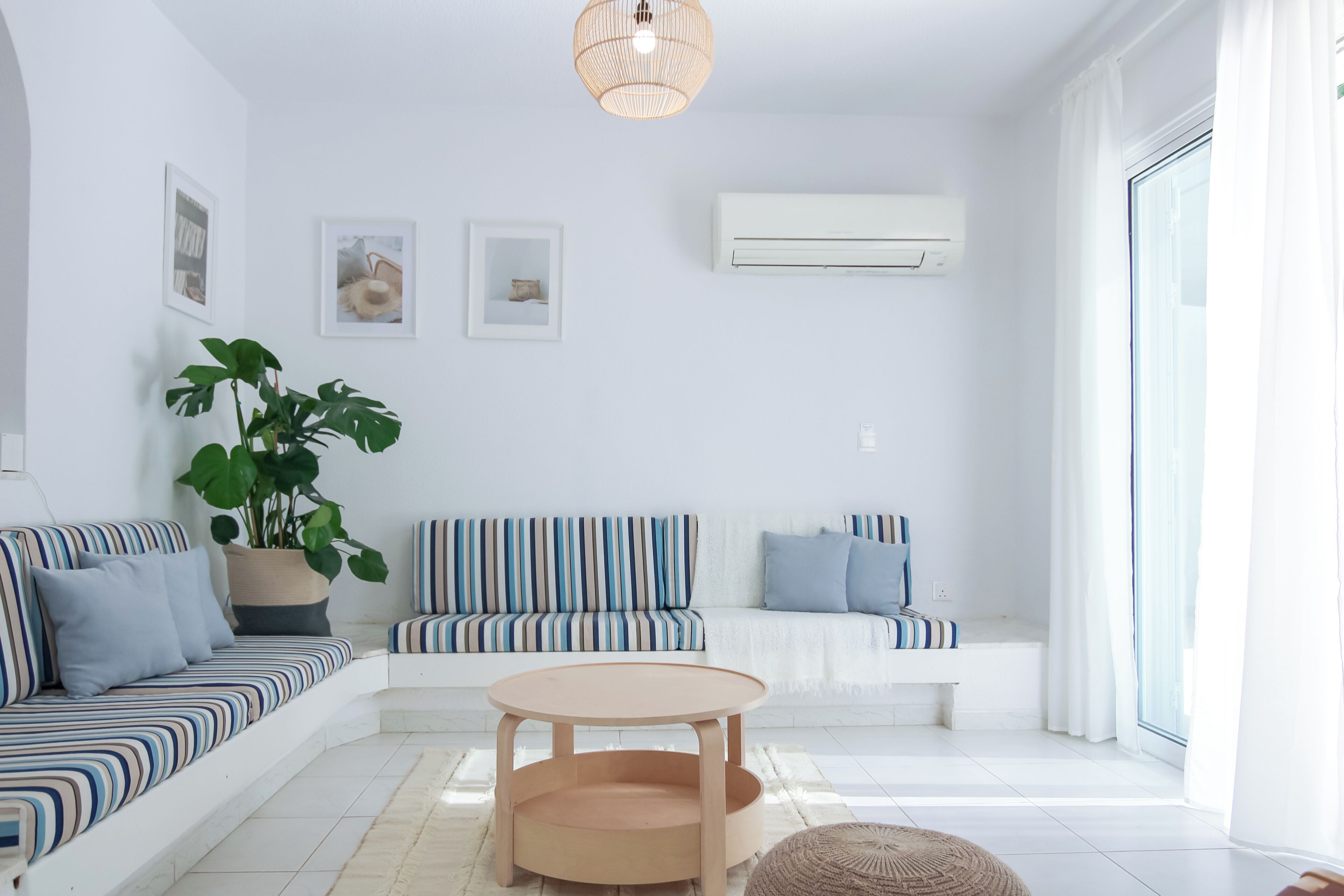 Un salon moderne avec un canapé, une table ronde et une plante en pot.