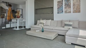 Una sala de estar moderna con sofá, mesa de centro y arte abstracto en la pared.