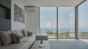 Una sala de estar moderna con un sofá, una mesa de centro y vistas a través de amplios ventanales.
