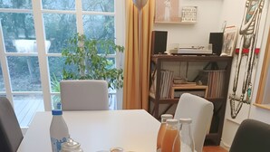 A breakfast table with various food items, a bottle, and a bowl.