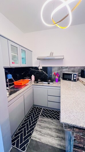 Una cuina moderna amb fogó de gas, microones i forn integrat.