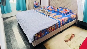Ein Schlafzimmer mit Bett, Vorhängen, einem Spiegel und einer Wand-Klimaanlage.
