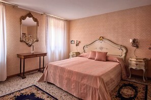 A bedroom with a large bed, a nightstand, a dresser, a mirror, and a window with curtains. - Refined apartment with terrace in Santa Croce (Santa Croce)