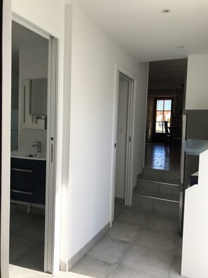 Ein Flur mit Bad auf der linken Seite, einer Treppe in der Mitte und einer Küchenzeile auf der rechten Seite.