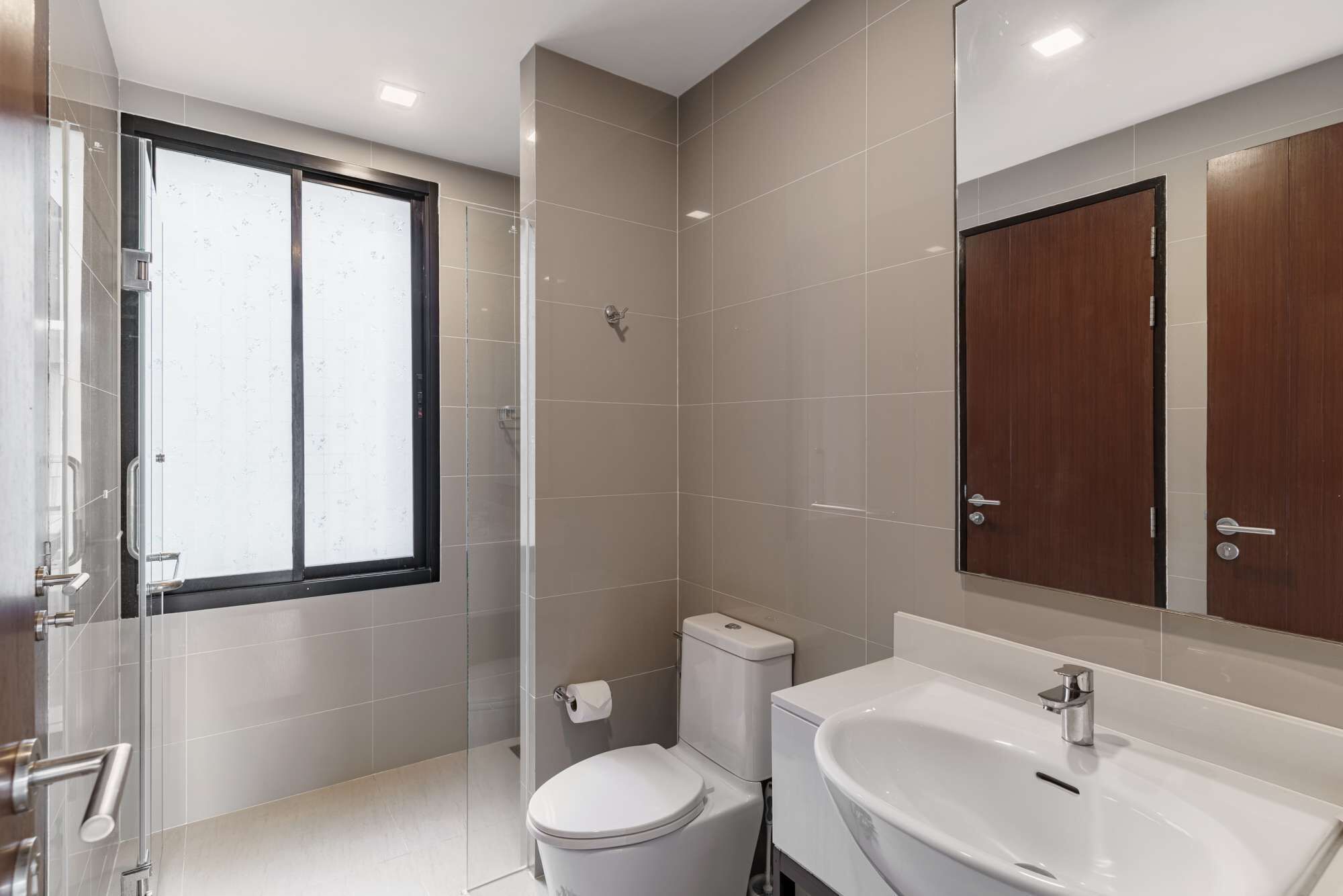Une salle de bain moderne avec des toilettes, un lavabo et un grand miroir.