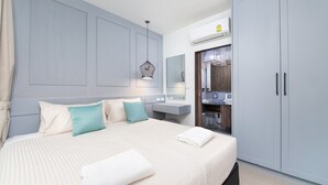 Ein Hotelzimmer mit Bett, Schminktisch mit Spiegel und Kleiderschrank.