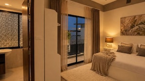 A bedroom with a bed, bedside table, lamp, and a view through the window. - 3BR Townhouse with Jacuzzi & Lake View |CapitalPro (Tambon Choeng Thale)