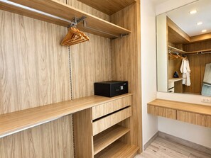 Une salle de bain moderne avec des meubles en bois, une radio noire et un miroir qui reflète une robe et une serviette.