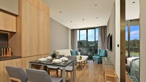 Eine moderne Küche mit Holzausstattung, einem Esstisch für vier Personen und einem großen Fenster mit Blick ins Freie.