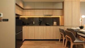 Eine moderne Küche mit Holzausbau, einem Einbauherd und einem Essbereich mit Stühlen.