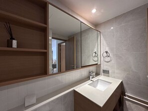 A modern bathroom with a large mirror, a white sink, and a towel ring. - 2 bdr Apartments Laguna Beachside 50m from Beach (Choeng Thale)