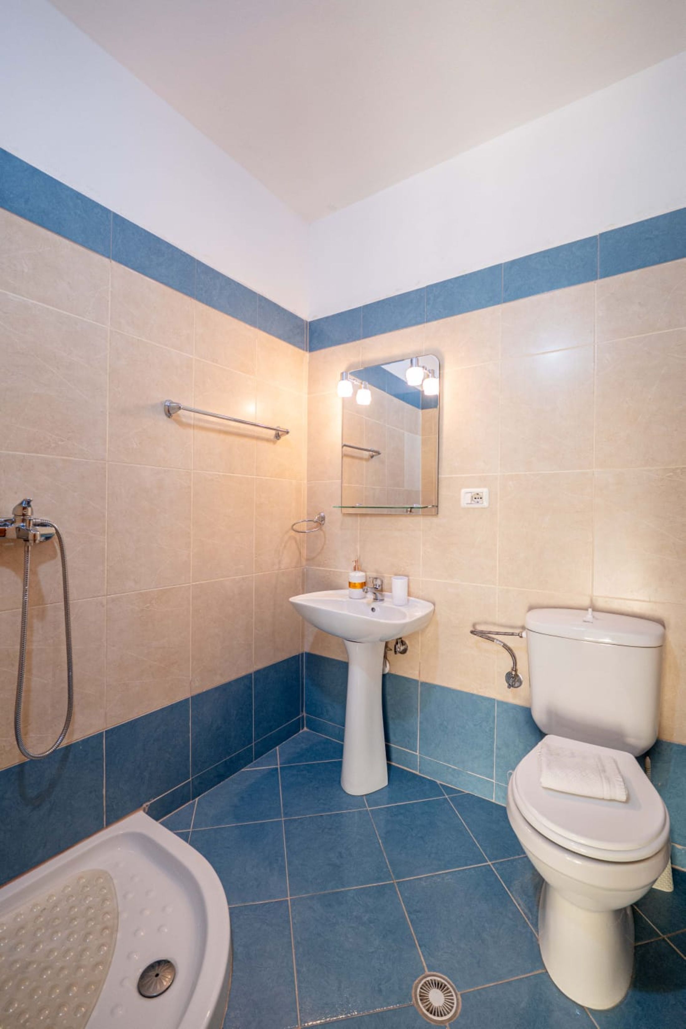 A bathroom with a bathtub, sink, toilet, and a mirror.